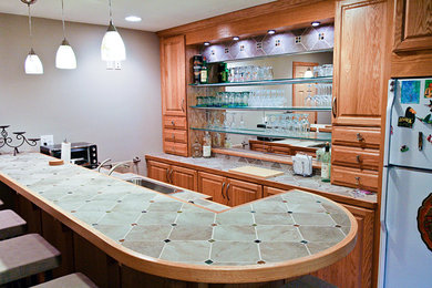 Diseño de cocina clásica con encimera de azulejos, fregadero encastrado, puertas de armario de madera oscura y salpicadero de vidrio templado