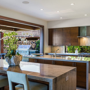 Foto di una cucina tropicale con lavello sottopiano, ante lisce, ante in legno bruno, paraspruzzi beige, elettrodomestici in acciaio inossidabile, 2 o più isole e pavimento beige