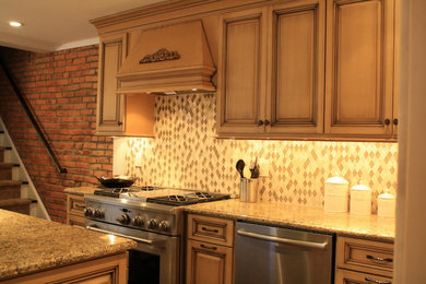 Example of a small classic l-shaped ceramic tile eat-in kitchen design in Philadelphia with an undermount sink, raised-panel cabinets, yellow cabinets, granite countertops, multicolored backsplash, glass tile backsplash, stainless steel appliances and an island