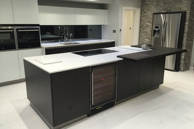 Inspiration for a large contemporary single-wall open plan kitchen in Other with a built-in sink, flat-panel cabinets, white cabinets, quartz worktops, grey splashback, glass sheet splashback, stainless steel appliances, marble flooring and an island.