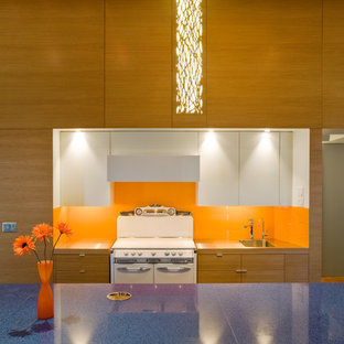 Contemporary galley kitchen in Omaha with an integrated sink, orange splashback, white appliances and blue benchtop.