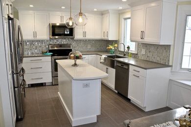 Eat-in kitchen - mid-sized transitional l-shaped porcelain tile and gray floor eat-in kitchen idea in Boston with a farmhouse sink, shaker cabinets, white cabinets, quartz countertops, gray backsplash, mosaic tile backsplash, stainless steel appliances and an island