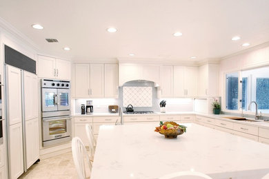 Mid-sized transitional u-shaped eat-in kitchen photo in Los Angeles with an undermount sink, recessed-panel cabinets, white cabinets, marble countertops, blue backsplash, ceramic backsplash, stainless steel appliances and an island