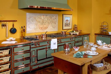 Inspiration for a traditional enclosed kitchen in Philadelphia with recessed-panel cabinets, green cabinets, copper worktops, coloured appliances, dark hardwood flooring, an island and brown floors.