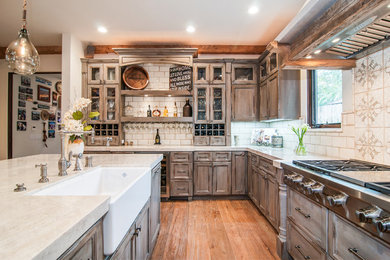 Tuscan l-shaped medium tone wood floor kitchen photo in San Diego with a farmhouse sink, shaker cabinets, medium tone wood cabinets, white backsplash, subway tile backsplash, stainless steel appliances and an island