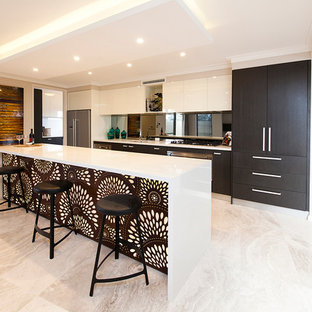 Immagine di una cucina contemporanea con ante lisce, ante in legno bruno, paraspruzzi a specchio, elettrodomestici in acciaio inossidabile e pavimento beige