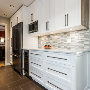 Inspiration for a small scandinavian galley separate kitchen in Montreal with an undermount sink, shaker cabinets, white cabinets, grey splashback, glass tile splashback, stainless steel appliances, ceramic floors and no island.