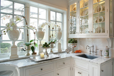 Example of a classic u-shaped eat-in kitchen design in New York with an undermount sink, recessed-panel cabinets, white cabinets, marble countertops, white backsplash, ceramic backsplash and stainless steel appliances