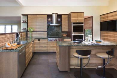 Inspiration for a mid-sized modern l-shaped porcelain tile eat-in kitchen remodel in San Francisco with flat-panel cabinets, granite countertops, an island, a single-bowl sink, medium tone wood cabinets, green backsplash and stainless steel appliances