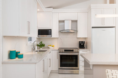 他の地域にある高級な中くらいなコンテンポラリースタイルのおしゃれなキッチン (アンダーカウンターシンク、シェーカースタイル扉のキャビネット、白いキャビネット、珪岩カウンター、白いキッチンパネル、セラミックタイルのキッチンパネル、シルバーの調理設備、セラミックタイルの床、白い床、白いキッチンカウンター) の写真