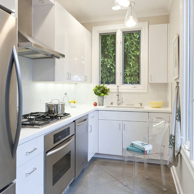 Trendy l-shaped enclosed kitchen photo in Los Angeles with stainless steel appliances, an undermount sink, flat-panel cabinets, white cabinets, white backsplash and mosaic tile backsplash