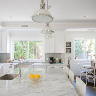 Large transitional open concept kitchen ideas - Inspiration for a large transitional l-shaped dark wood floor open concept kitchen remodel in Los Angeles with shaker cabinets, white cabinets, an undermount sink, marble countertops, gray backsplash, glass sheet backsplash, stainless steel appliances and an island