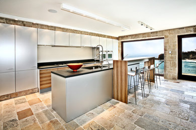 Imagen de cocina lineal minimalista con fregadero bajoencimera, armarios con paneles lisos, electrodomésticos de acero inoxidable y una isla