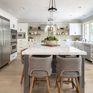 Transitional kitchen designs - Kitchen - transitional light wood floor kitchen idea in Orange County with a farmhouse sink, quartz countertops, cement tile backsplash, stainless steel appliances, an island and white countertops