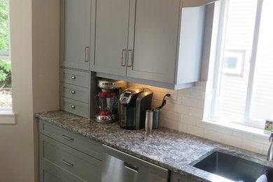 Example of a large trendy l-shaped eat-in kitchen design in Vancouver with an undermount sink, shaker cabinets, gray cabinets, quartz countertops, white backsplash, ceramic backsplash, stainless steel appliances and an island