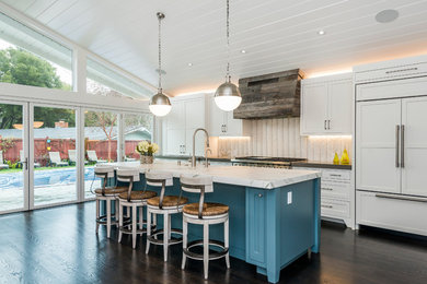 Mid-sized transitional single-wall dark wood floor and brown floor eat-in kitchen photo in San Francisco with a farmhouse sink, shaker cabinets, white cabinets, marble countertops, white backsplash, stainless steel appliances, an island and matchstick tile backsplash