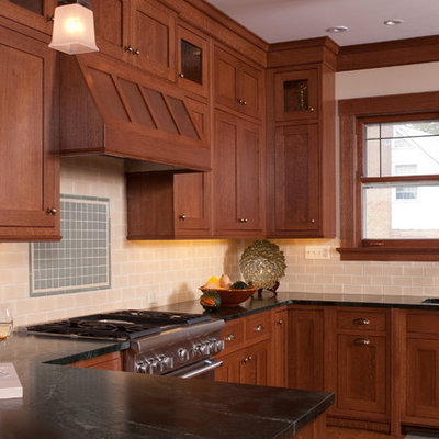 Example of an arts and crafts u-shaped eat-in kitchen design in Chicago with shaker cabinets, medium tone wood cabinets, soapstone countertops, beige backsplash, subway tile backsplash, stainless steel appliances and an undermount sink
