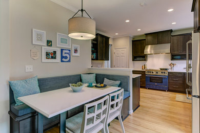 Mid-sized transitional l-shaped bamboo floor eat-in kitchen photo in Raleigh with a double-bowl sink, shaker cabinets, dark wood cabinets, quartz countertops, white backsplash, ceramic backsplash, colored appliances and no island