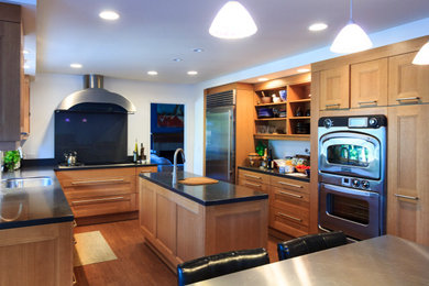 Eat-in kitchen - mid-sized transitional u-shaped cork floor and brown floor eat-in kitchen idea in Orange County with a single-bowl sink, recessed-panel cabinets, medium tone wood cabinets, quartz countertops, black backsplash, quartz backsplash, stainless steel appliances, an island and black countertops