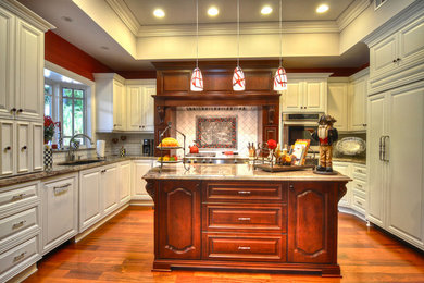 Photo of a traditional kitchen in Orange County with raised-panel cabinets, white cabinets, granite worktops, white splashback, integrated appliances, medium hardwood flooring and an island.