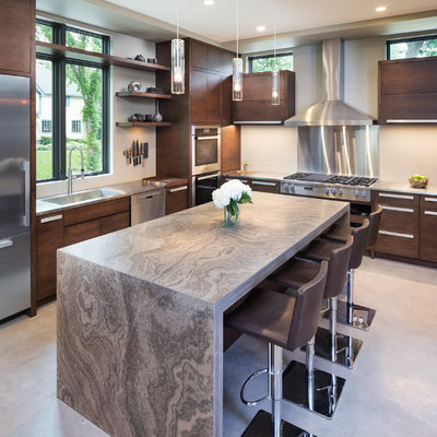 Mid-sized minimalist concrete floor kitchen photo in Minneapolis with flat-panel cabinets, limestone countertops, beige backsplash, stainless steel appliances, an island and dark wood cabinets