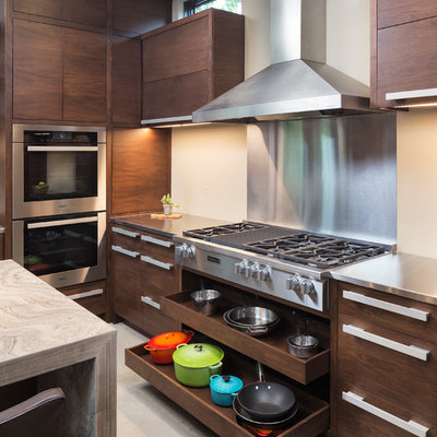 Inspiration for a small modern concrete floor kitchen remodel in Minneapolis with flat-panel cabinets, medium tone wood cabinets, limestone countertops, beige backsplash, stainless steel appliances and an island