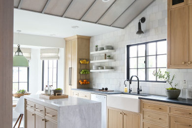 Inspiration for a coastal ceramic tile and gray floor eat-in kitchen remodel in Orange County with light wood cabinets, marble countertops, a farmhouse sink, marble backsplash, stainless steel appliances and an island