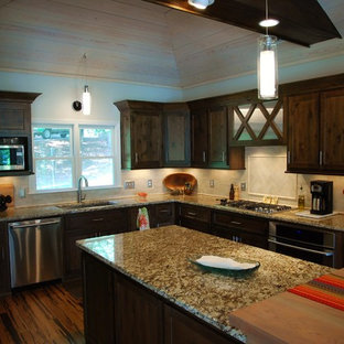 Mid-sized traditional open concept kitchen designs - Mid-sized elegant galley bamboo floor and brown floor open concept kitchen photo in Atlanta with an undermount sink, recessed-panel cabinets, dark wood cabinets, granite countertops, white backsplash, ceramic backsplash, stainless steel appliances and two islands