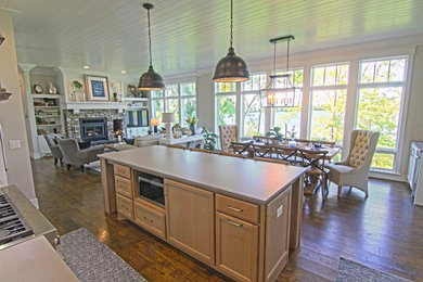 Imagen de cocina comedor rústica con suelo de madera en tonos medios, una isla y suelo marrón