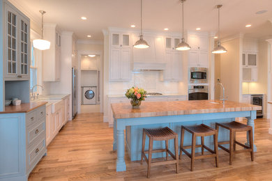 Example of a classic eat-in kitchen design in Other with a farmhouse sink, flat-panel cabinets, white cabinets, granite countertops, white backsplash, subway tile backsplash and stainless steel appliances