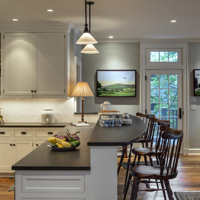 Elegant eat-in kitchen photo in New York with shaker cabinets, beige cabinets, stainless steel appliances and white backsplash