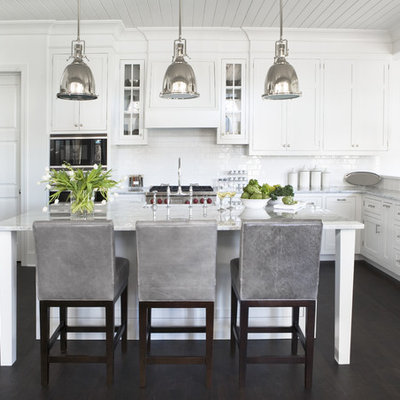 Kitchen - large traditional u-shaped dark wood floor kitchen idea in Other with stainless steel appliances, marble countertops, shaker cabinets, white cabinets, white backsplash, subway tile backsplash and an island