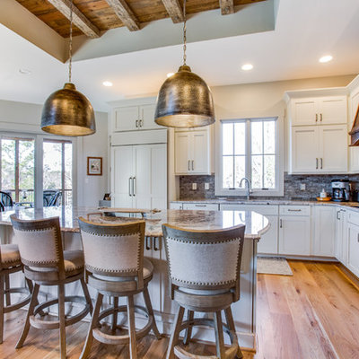 Eat-in kitchen - mid-sized rustic l-shaped medium tone wood floor and beige floor eat-in kitchen idea in Birmingham with shaker cabinets, white cabinets, granite countertops, an island, gray backsplash and stainless steel appliances