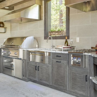 Inspiration for an expansive contemporary l-shaped kitchen in Birmingham with a farmhouse sink, louvered cabinets, distressed cabinets, granite benchtops, stainless steel appliances and concrete floors.