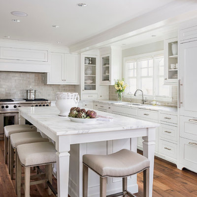 Kitchen - mid-sized traditional l-shaped dark wood floor kitchen idea in Minneapolis with recessed-panel cabinets, subway tile backsplash, paneled appliances, white cabinets, marble countertops, gray backsplash, an undermount sink, an island and white countertops
