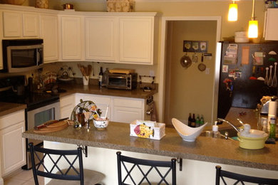 Example of a mid-sized danish l-shaped ceramic tile kitchen pantry design in Atlanta with a double-bowl sink, flat-panel cabinets, white cabinets, granite countertops, beige backsplash, stone slab backsplash, stainless steel appliances and an island