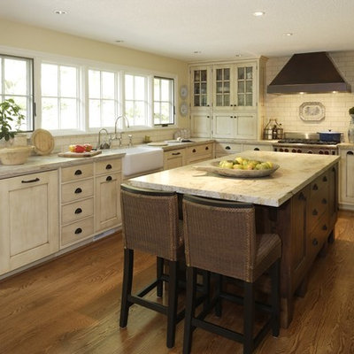Example of a large country l-shaped dark wood floor and brown floor eat-in kitchen design in Portland with a farmhouse sink, white cabinets, white backsplash, subway tile backsplash, marble countertops, an island, stainless steel appliances, white countertops and beaded inset cabinets