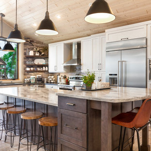 Kitchen - rustic l-shaped medium tone wood floor and brown floor kitchen idea in Other with shaker cabinets, white cabinets, stainless steel appliances, an island and beige countertops