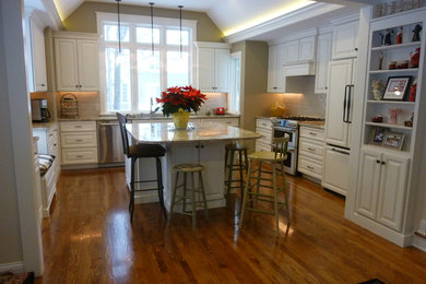 Example of a mid-sized classic u-shaped dark wood floor enclosed kitchen design in Cleveland with an undermount sink, raised-panel cabinets, white cabinets, granite countertops, beige backsplash, ceramic backsplash, stainless steel appliances and an island