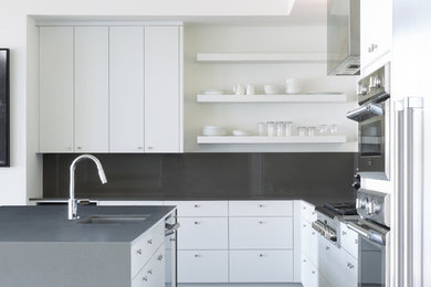 Große Moderne Wohnküche mit flächenbündigen Schrankfronten, weißen Schränken und Kücheninsel in Austin