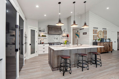Inspiration for a coastal vinyl floor and multicolored floor kitchen remodel in Other with a farmhouse sink, shaker cabinets, distressed cabinets, white backsplash, black appliances, an island and white countertops