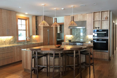 Example of a large transitional l-shaped brown floor and medium tone wood floor eat-in kitchen design in Portland Maine with flat-panel cabinets, medium tone wood cabinets, granite countertops, stainless steel appliances, an island, a double-bowl sink, beige backsplash and stone slab backsplash