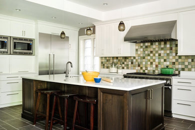 Example of a mid-sized transitional galley porcelain tile open concept kitchen design in Chicago with an undermount sink, shaker cabinets, white cabinets, quartzite countertops, green backsplash, stainless steel appliances, an island and ceramic backsplash