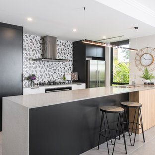 Photo of a mid-sized contemporary galley open plan kitchen in Perth with an undermount sink, flat-panel cabinets, black cabinets, concrete benchtops, black appliances, porcelain floors, grey floor, grey benchtop and multi-coloured splashback.