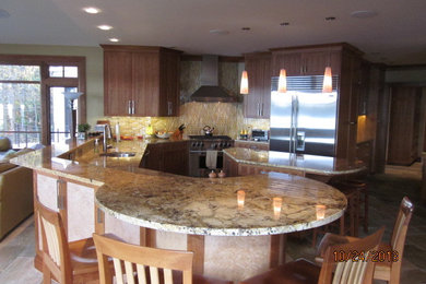 Huge trendy u-shaped slate floor eat-in kitchen photo in Boston with an undermount sink, recessed-panel cabinets, light wood cabinets, granite countertops, metallic backsplash, stainless steel appliances and an island