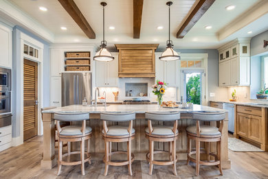 Inspiration for a coastal u-shaped medium tone wood floor and brown floor eat-in kitchen remodel in Other with an undermount sink, shaker cabinets, medium tone wood cabinets, white backsplash, stainless steel appliances, an island and white countertops