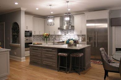 Kitchen - transitional light wood floor kitchen idea in Charlotte with an undermount sink, flat-panel cabinets, quartz countertops, gray backsplash, stainless steel appliances and an island