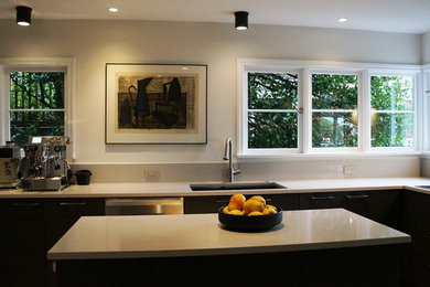 Immagine di una cucina design chiusa e di medie dimensioni con lavello a doppia vasca, ante lisce, ante marroni, top in quarzo composito, paraspruzzi beige, elettrodomestici in acciaio inossidabile, pavimento in gres porcellanato, pavimento grigio e top beige