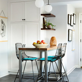 Mid-sized transitional galley eat-in kitchen in DC Metro with a farmhouse sink, shaker cabinets, white cabinets, quartzite benchtops, green splashback, ceramic splashback, stainless steel appliances, slate floors, a peninsula, black floor, grey benchtop and exposed beam.