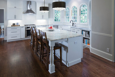 Example of a large danish dark wood floor and brown floor open concept kitchen design in Atlanta with a farmhouse sink, shaker cabinets, white cabinets, quartzite countertops, white backsplash, ceramic backsplash, stainless steel appliances and an island
